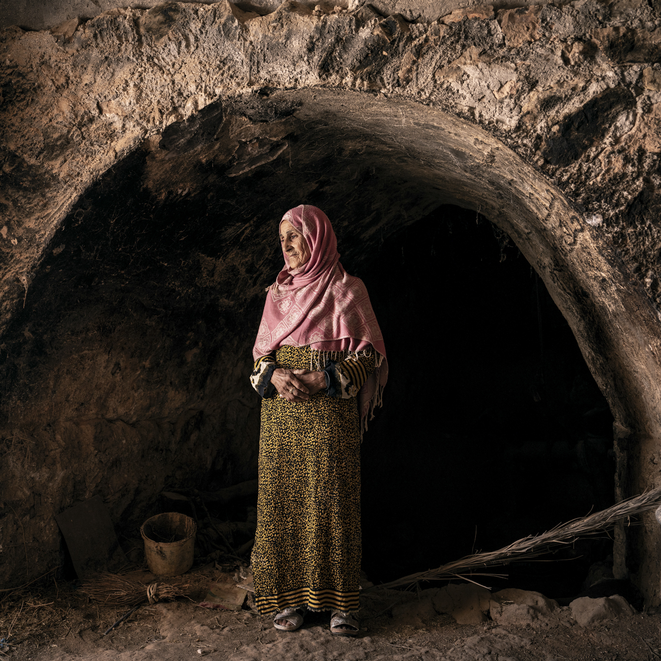 Fatma Hamdi, 73, jabs a giant iron key impatiently into the lock in a heavy palm wood door, pushing it open to allow sunlight to stream in. Inside, there is a centuries-old olive press in a cave next to the family home. Several generations ago when the wheel last turned, a horse would pull the stone round in the dark to squeeze the oil from olives that had dried in the sun for several weeks to be sold at market. Matmata, Tunisia 2023.